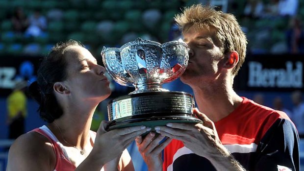 Matthew Ebden and Jarmila Gajdosova with their trophy. Behind them, the stands are virtually empty.