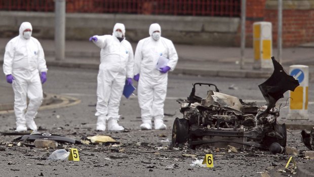 Forensic officers examine the remains of an exploded car bomb outside Newry Courthouse in Northern Ireland.