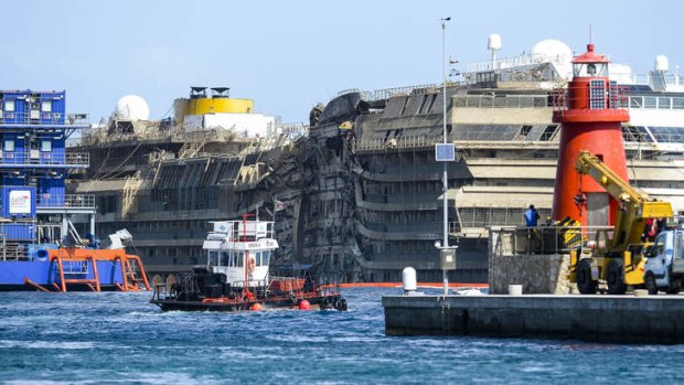 The wreckage of Italy's Costa Concordia cruise ship begins to emerge from water near the harbour of Giglio Porto after a salvage operation.