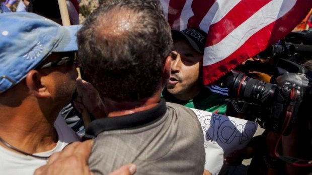 Singer Lipillo Rivera (centre, facing camera)  confronts those picketing against the arrival of undocumented migrants in California.