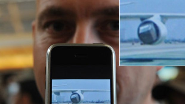 A passenger, Michael Charlton from Kansas, shows an image of the damaged engine on his iPhone after he was evacuated with from the Japan Airlines flight 61 to Tokyo.
