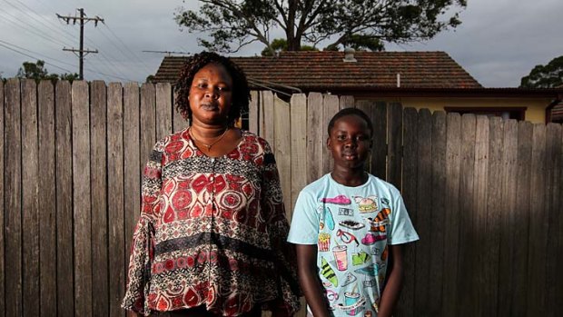 Home safe: Asunta Manok and her son Makuei, 10, after being evacuated (above); John Mac Acuek and his son