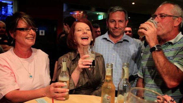 The Sydney Morning Herald and The Age have backed Prime Minister Julia Gillard, seen here enjoying a drink in Raymond Terrace last night.