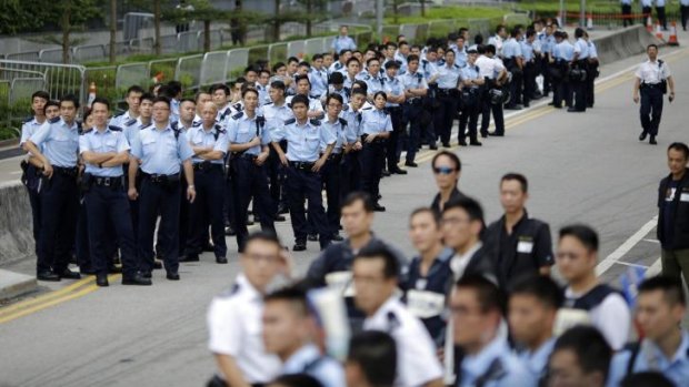 Powerless: Police officers gather as protesters block the entrance to Hong Kong's chief executive's offices.