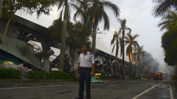 A security guard stands near a damaged shoe factory in Vietnam's Binh Duong province. 