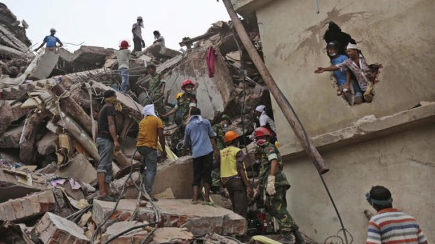 Bangladeshi rescue workers search for victims Friday, April 26, 2013 amid the rubble of a building that collapsed Wednesday in Savar, near Dhaka, Bangladesh.