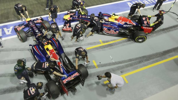 Tuning up:  Sebastian Vettel and Mark Webber's Red Bull cars are pushed under cover after a Singapore practice session.