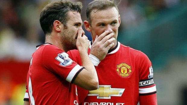 Wayne Rooney (R) and Juan Mata discuss tactics.