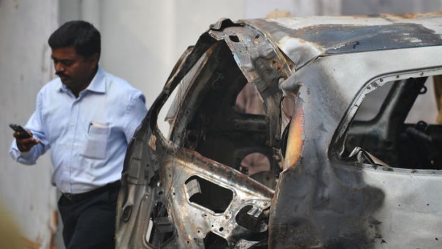 An investigator at Tughlaq Road police station next to a vehicle that exploded near the Israeli embassy in New Delhi.