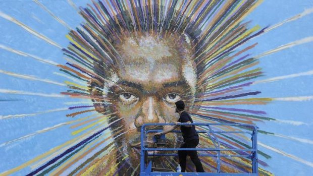 Painting a brighter future ... a street artist works on his spray-painted picture of Jamaican sprinter Usain Bolt in east London.