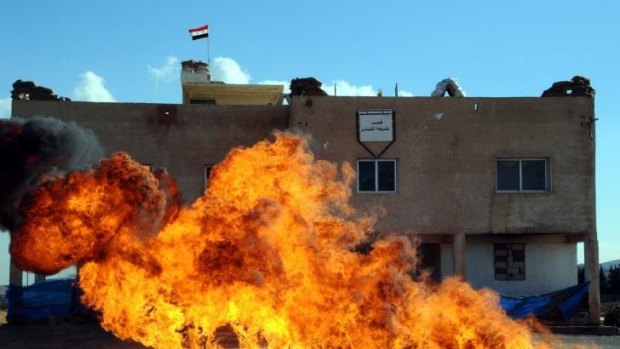 Fire burns below a Syrian flag in Nabak.