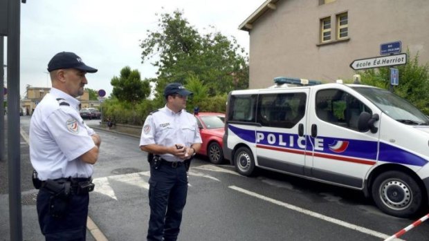 Policemen stand guard near the primary school Edouard-Herriot in the French town of Albi where a female teacher was stabbed to death in front of her pupils by a student's mother.