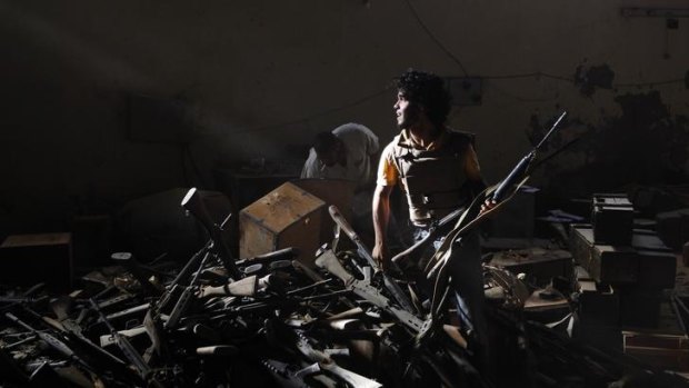 An anti-Gaddafi fighter at a pro-Gaddafi weapons and ammunition compound in a village near Sirte.