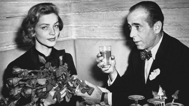 Lauren Bacall and Humphrey Bogart at a cocktail party in 1951.