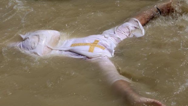 An Orthodox Christian pilgrim immerses himself in the Jordan River.