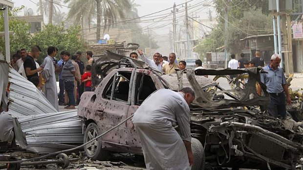 Residents inspect the site of a bomb attack in the town of Taji, about 20 km north of Baghdad.