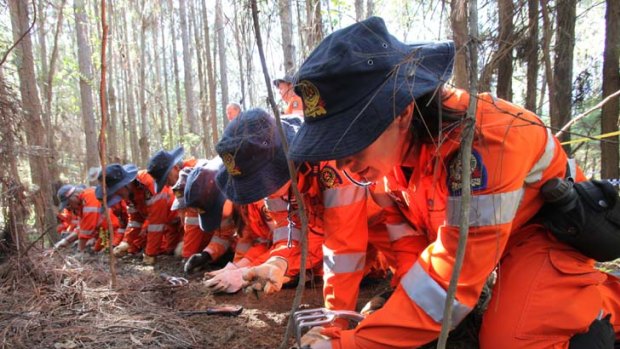 Police and SES volunteers search the bushland site last month.