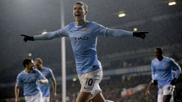 Winners: Edin Dzeko celebrates scoring Manchester City's third goal against Tottenham.