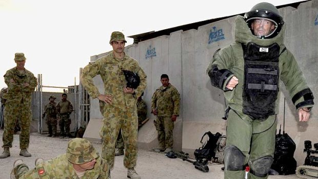 Full metal Abbott ... Tony Abbott tries out bomb-disposal gear during his visit to Tarin Kowt today.