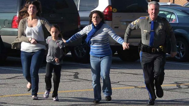 Terror: Two women and a child are led to safety from the Sandy Hook Elementary School massacre.