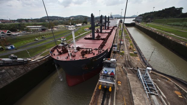 A ship makes its way through the Miraflores locks of the Panama Canal near Cocoli, Panama. A larger set of locks for the Panama Canal will soon double the amount of goods that can pass through it each year. 