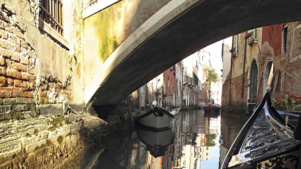 Gondola under a bridge in Venice.