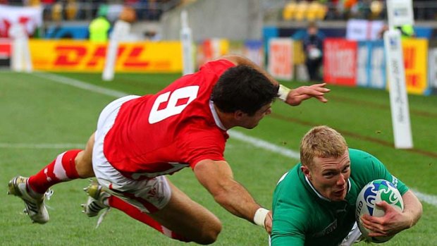 Winger Keith Earls of Ireland dives past Mike Phillips to score his team's only try.