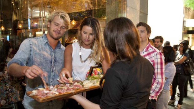 Grazing time &#8230; Abbie Oliver and Daniel Davill taste some of the offerings from Jamie Oliver's Sydney restaurant while they wait outside for a table.