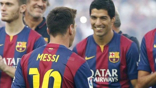 Luis Suarez greets teammate Lionel Messi during the team presentation at Nou Camp stadium in Barcelona on Monday.