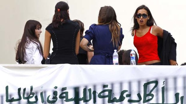 Causing a storm ... women invited to a meeting with Muammar Gaddafi wait for the Libyan leader.