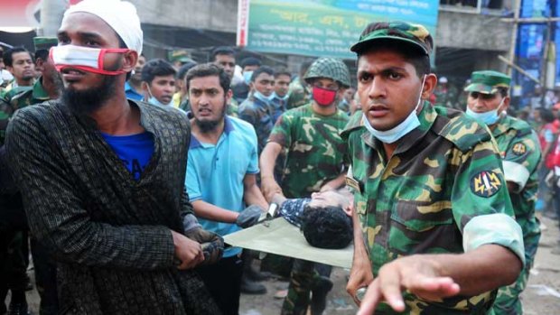 Bangladeshi army personel carry a survivor who was buried under rubble for 48 hours.