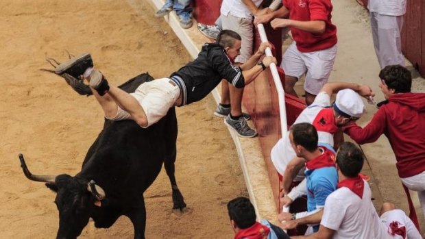 A runner tries to protect himself, at the San Fermin festival, in Pamplona.