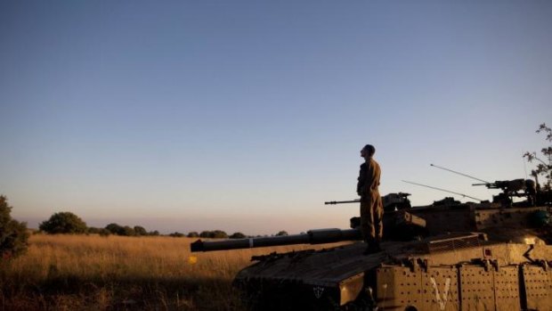 Praying: An Israeli soldier on a Merkava tank near the Israeli-Syrian border. An Israeli teen was killed that day in an attack near the border in the annexed Golan Heights. 