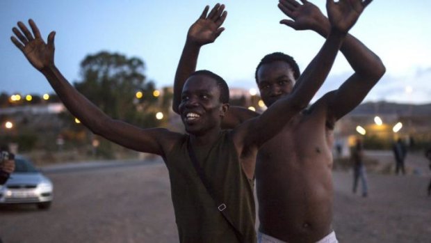 Free: Migrants celebrate after scaling the fence that divides Morocco and the Spanish enclave of Melilla.