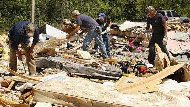 Alabama residents try to salvage belongings from a family's home after a tornado struck.