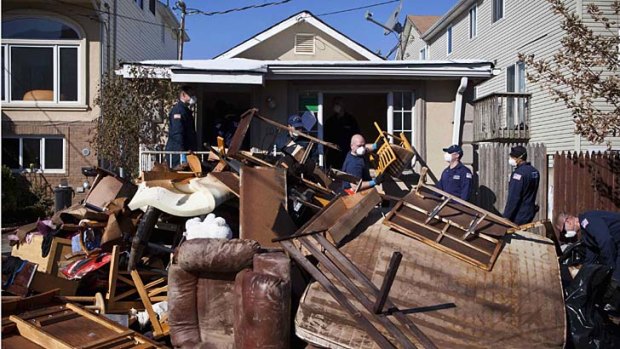 Ruined ... members of the US Coast Guard help clear a house in the Midland Beach area.
