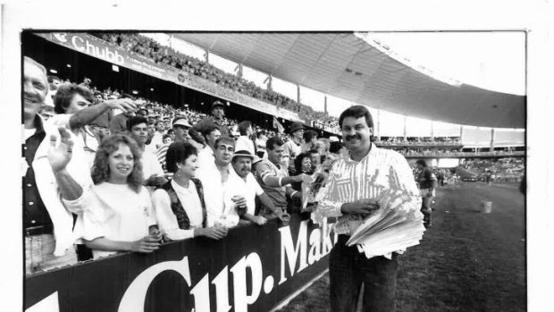 Canberra Times journalist Brad Turner hands out 'We Did It' posters after the Raiders win the 1989 grand final.