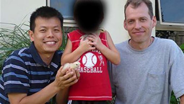 Peter Truong (left) and Mark Newton (right) with their son outside their home in Cairns.