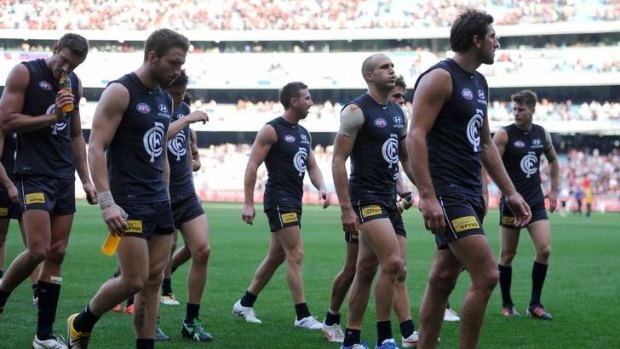 Long walk: Carlton players trudge off the ground after the loss to Essendon in April last year.