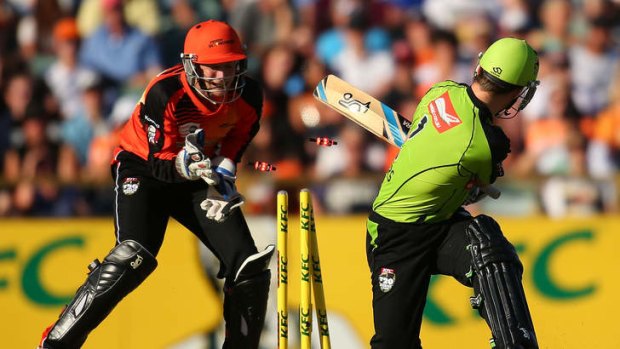 Ryan Carters of the Thunder is bowled by Brad Hogg of the Scorchers.