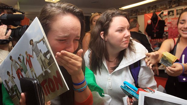 Beside herself ... A young fan bursts into tears after purchasing merchandise at the One Direction promotional store opening in Sydney at the weekend.