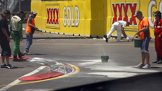 Get a grip ...workers put sand on an oil spill on the Olympic circuit.