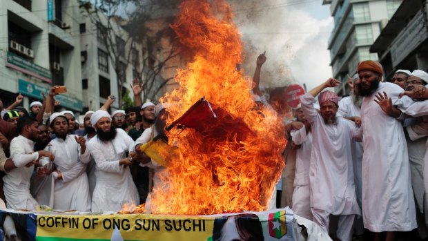 Bangladeshi activists burn the national flag of Myanmar during a protest rally against the persecution of Rohingya Muslims in Myanmar.