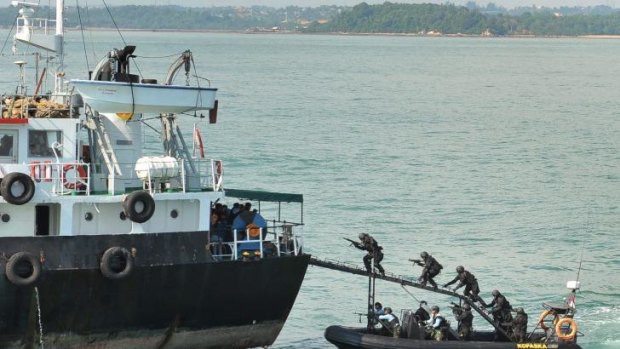 Law enforcers: Indonesian Navy Kopaska troops storm the "hijacked" vessel, MT Promise, off Batam Island, while it was cordoned by vessels from Singapore navy during an operation demonstration in 2012.