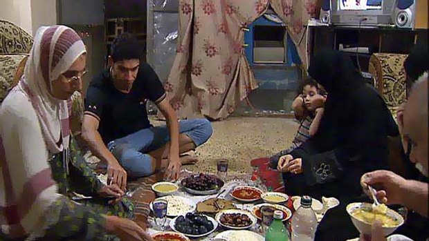 Zaheda Salem and her family eat an evening meal together on the seventh floor of an office building in Baghdad.