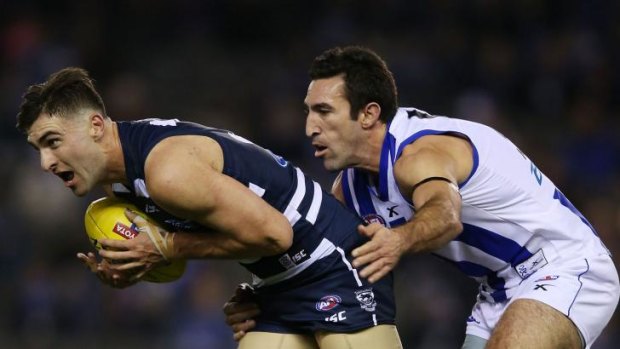 Michael Firrito of the Kangaroos tackles Shane Kersten of the Cats during Saturday night's game.