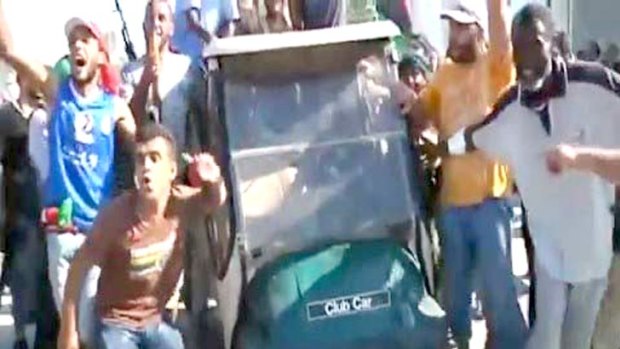 TV crews capture rebels parading spoils from the Gaddafi compound, including this golf cart.