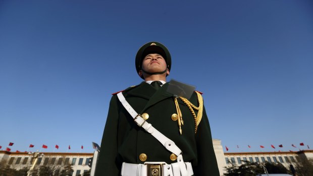 A paramilitary police officer stands outside the Great Hall of the People in Beijing, China.