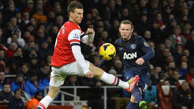 Manchester United's Wayne Rooney (R) is challenged by Arsenal's Laurent Koscielny.