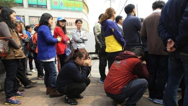 Parents wait for a bus to meet with their children rescued from a ferry that sank off the country's southern coast, at Danwon high school in Ansan, South Korea.